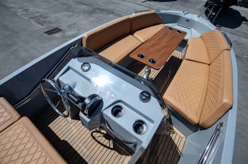 Slide: The Image of 2022 Rand BREEZE boat interior with tan seating and wooden table. - 7