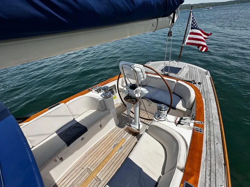Slide: The Image of Alerion Express 38 sailboat cockpit with American flag, 2009 model, on calm water. - 11