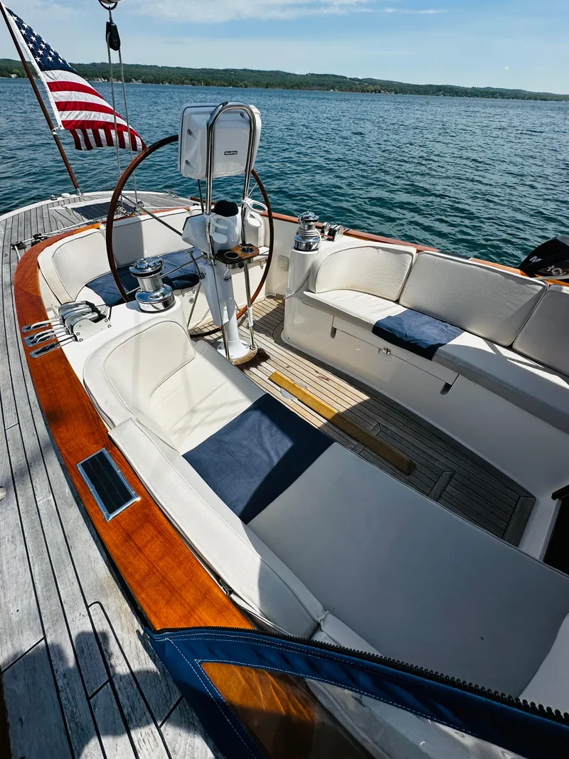 Slide: The Image of 2009 Alerion Express 38 sailboat with elegant cockpit and American flag on serene water. - 12