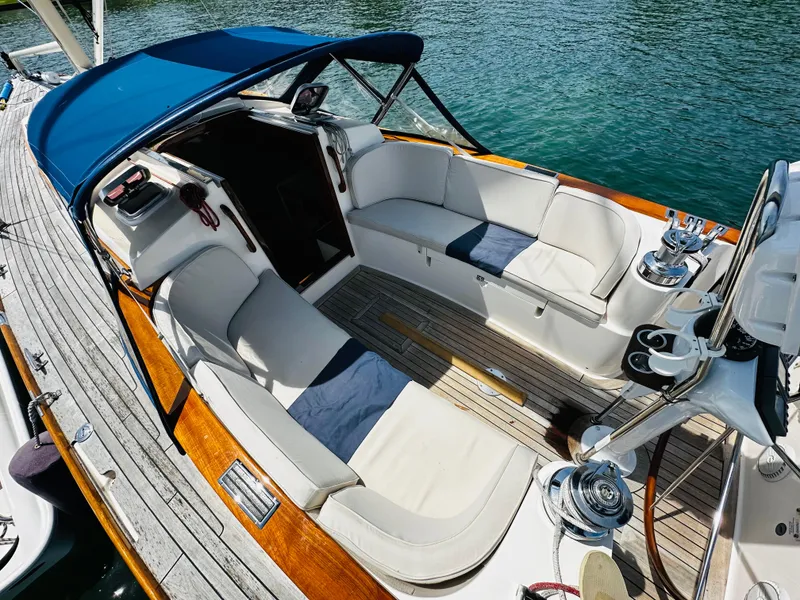 Slide: The Image of 2009 Alerion Express 38 sailboat cockpit with cushioned seating and blue canopy. - 13
