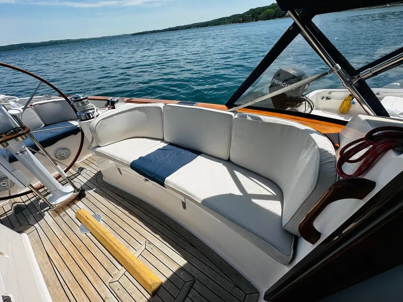 Slide: The Image of Alerion Express 38 sailboat cockpit with white seating, wooden deck, and scenic water view. - 14