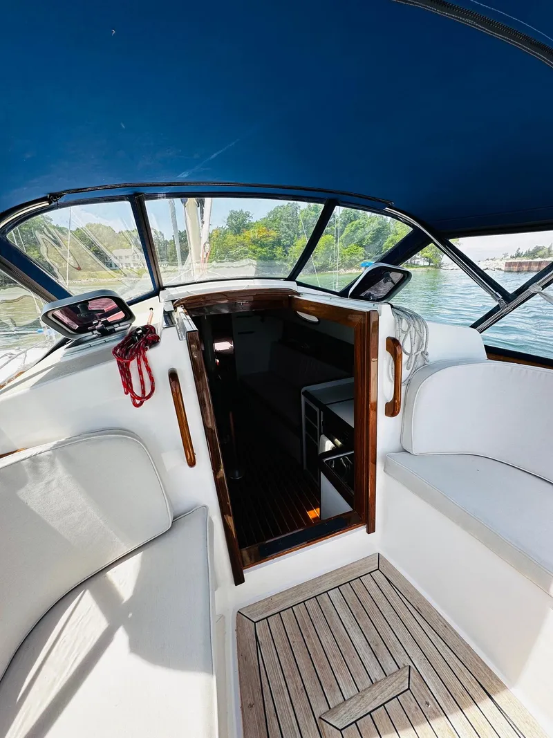 Slide: The Image of 2009 Alerion Express 38 sailboat cockpit with blue canopy and wooden flooring. - 16