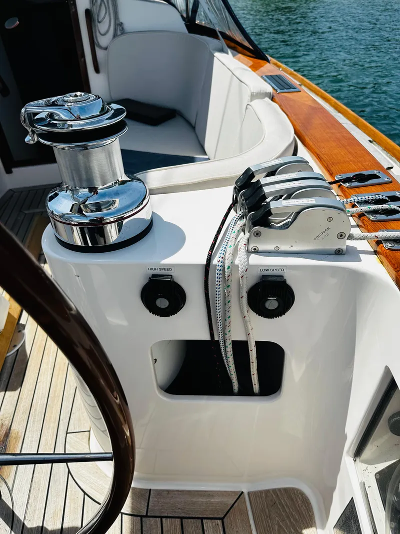 Slide: The Image of 2009 Alerion Express 38 sailboat cockpit with winch and control panel, featuring sleek design and wood accents. - 18