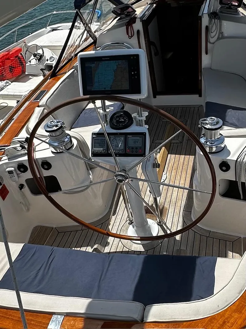 Slide: The Image of 2009 Alerion Express 38 sailboat cockpit with navigation equipment and wooden steering wheel. - 19