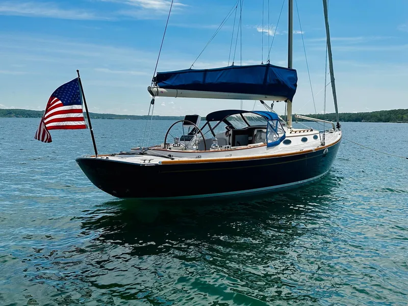 Slide: The Image of Sailing yacht Alerion Express 38, 2009 model, on calm waters with American flag. - 2