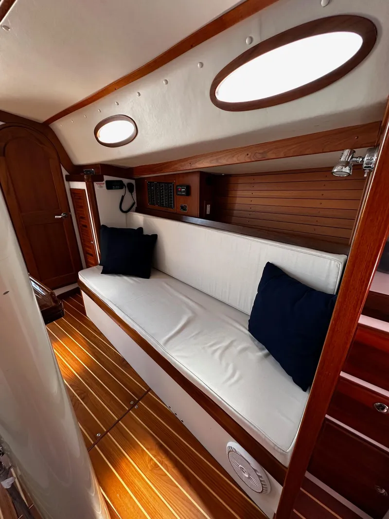 Slide: The Image of Interior of 2009 Alerion Express 38 sailboat with white seating and wooden accents. - 25