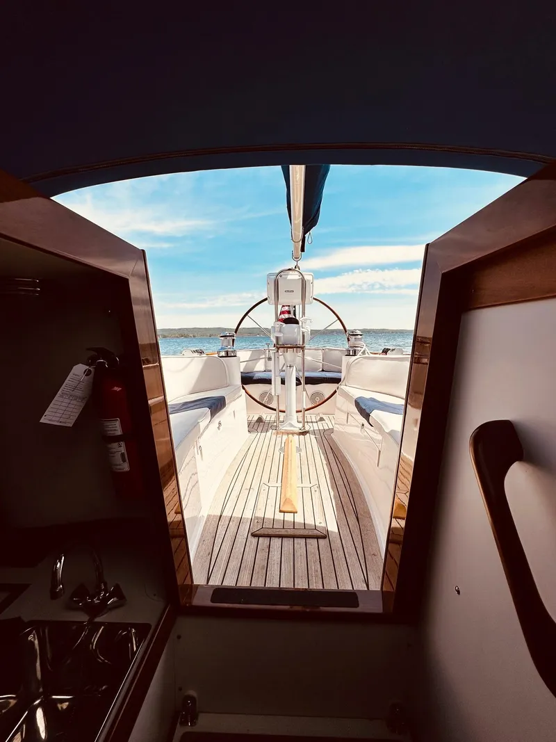 Slide: The Image of Interior view of 2009 Alerion Express 38 sailboat, showcasing helm and deck under blue sky. - 31