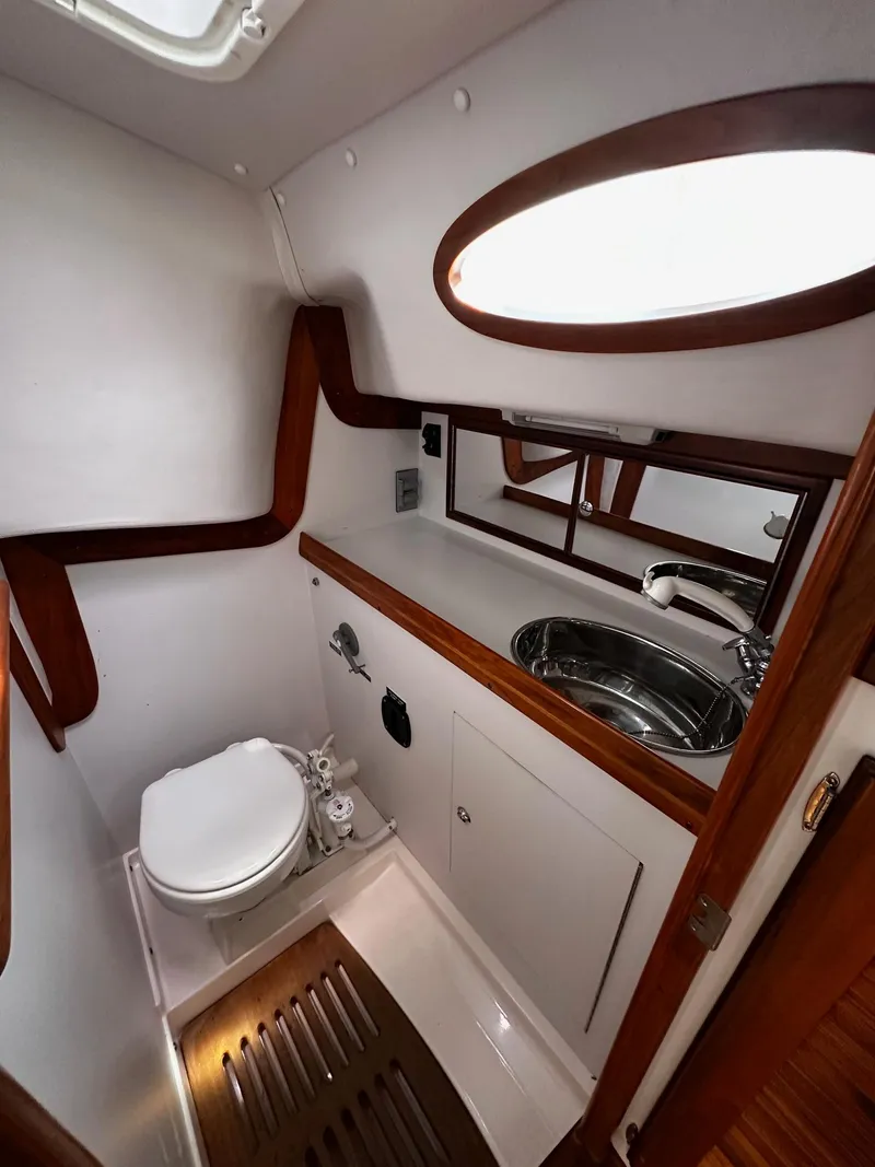 Slide: The Image of 2009 Alerion Express 38 yacht bathroom with sink, toilet, and wooden accents. - 33