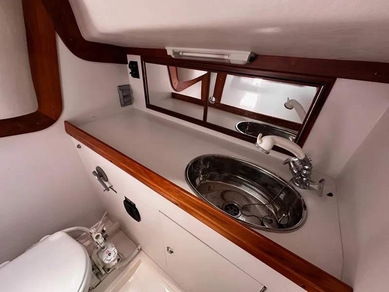 Slide: The Image of 2009 Alerion Express 38 yacht bathroom with sink, mirror, and wooden accents. - 34