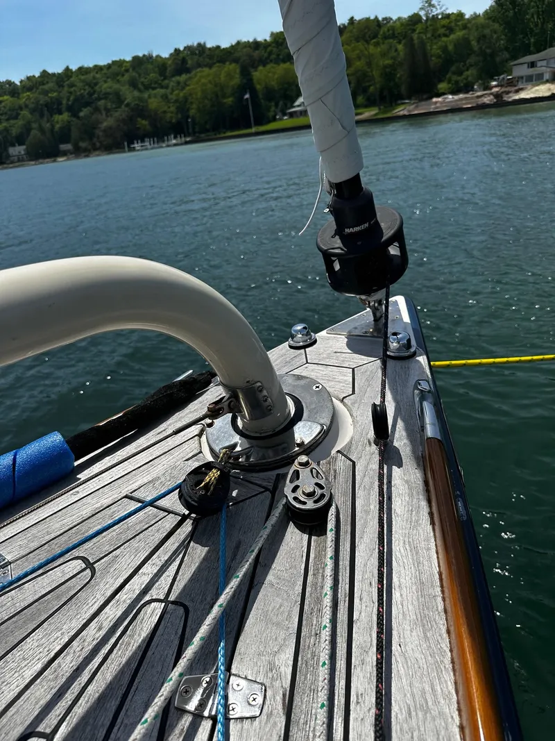 Slide: The Image of Alerion Express 38 sailboat deck, 2009 model, on calm water with lush shoreline. - 37