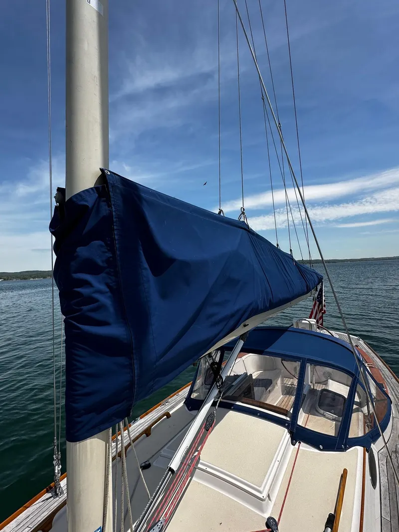 Slide: The Image of 2009 Alerion Express 38 sailboat with blue sail cover on calm water. - 40