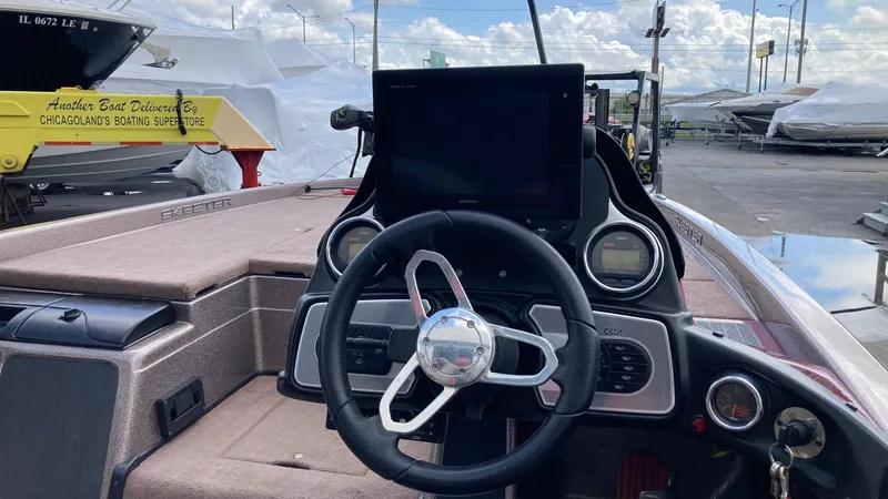 Slide: The Image of 2012 Skeeter FX20 fishing boat deck with rods and equipment on a calm lake. - 4