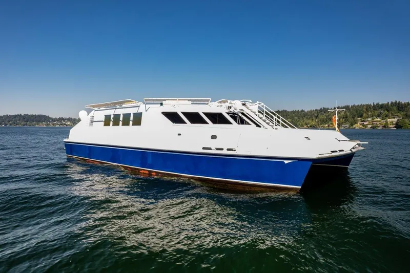 Slide: The Image of Dakota Creek 1999 catamaran, helicopter capable, on calm water under clear blue sky. - 13