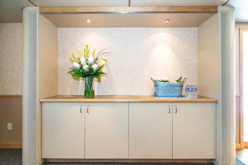 Slide: The Image of Luxurious catamaran interior with floral arrangement and refreshments on a wooden cabinet, 1999 model. - 27