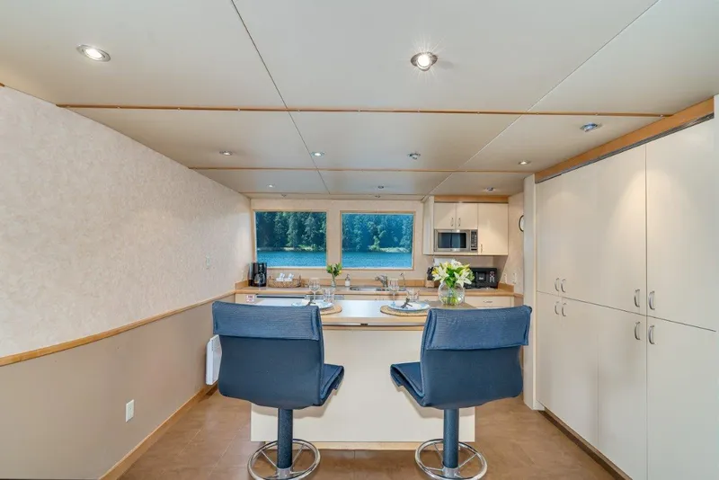 Slide: The Image of Modern catamaran interior with kitchen, bar stools, and large windows, Dakota Creek 1999 model. - 31