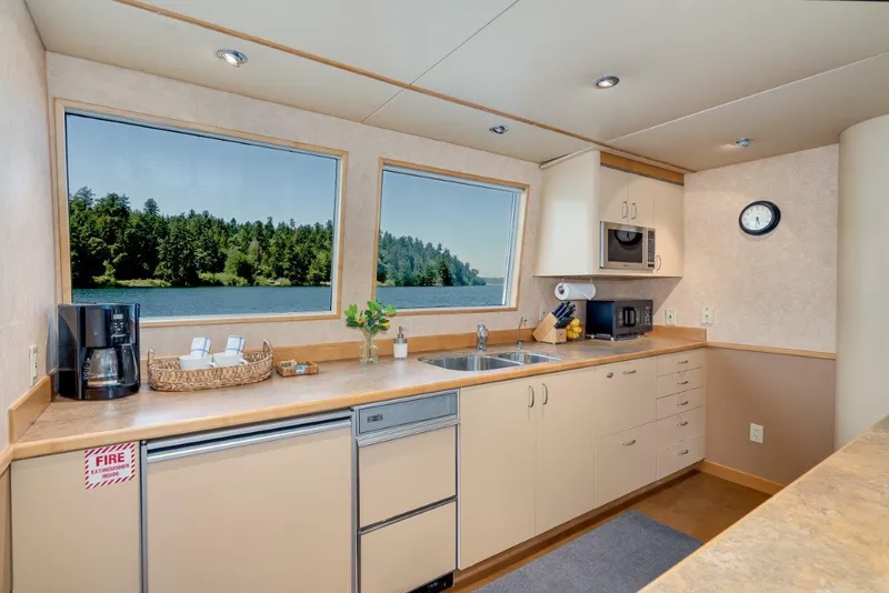Slide: The Image of Modern kitchen interior on 1999 Dakota Creek Catamaran, featuring large windows with scenic views. - 33