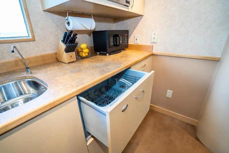 Slide: The Image of Modern catamaran kitchen with open dishwasher, microwave, and countertop accessories. Dakota Creek, 1999 model. - 34