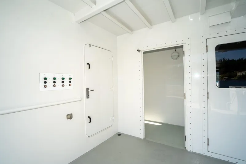 Slide: The Image of Interior of 1999 Dakota Creek Catamaran, featuring white walls and control panel. - 40