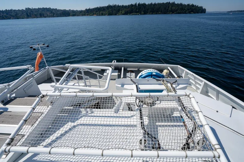 Slide: The Image of Dakota Creek 1999 catamaran with helicopter capability on calm water, featuring safety netting. - 47