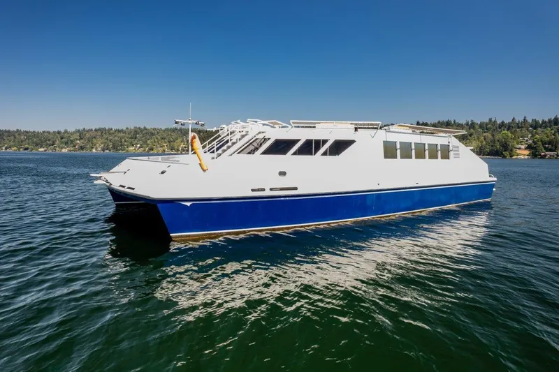 Slide: The Image of Dakota Creek 1999 catamaran, helicopter capable, on calm water under clear blue sky. - 9