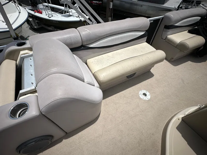 Slide: The Image of 2010 Bennington 2250RCW boat interior with beige and gray seating. - 13