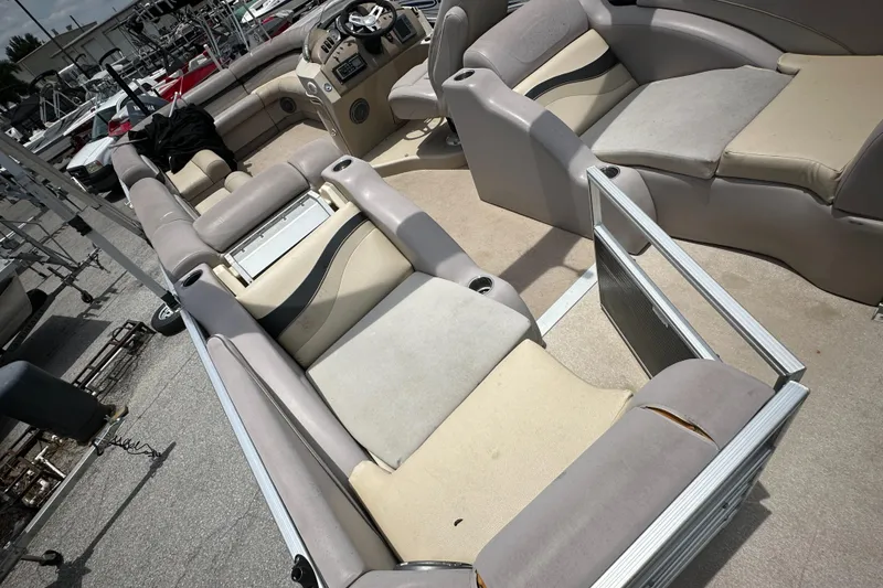 Slide: The Image of 2010 Bennington 2250RCW pontoon boat interior with beige and gray seating. - 18