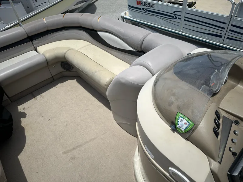 Slide: The Image of 2010 Bennington 2250RCW pontoon boat interior with beige seating and control console. - 6