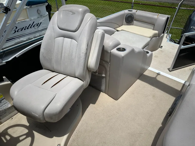 Slide: The Image of 2010 Bennington 2250RCW boat interior with beige seating and cup holders. - 9