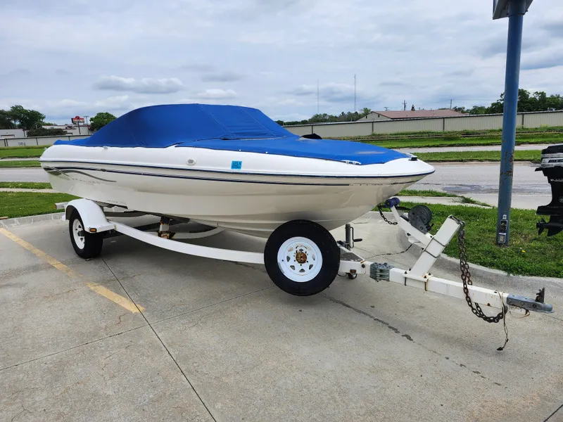 Slide: The Image of 2002 Bayliner 215 Capri boat on trailer with blue cover. - 10
