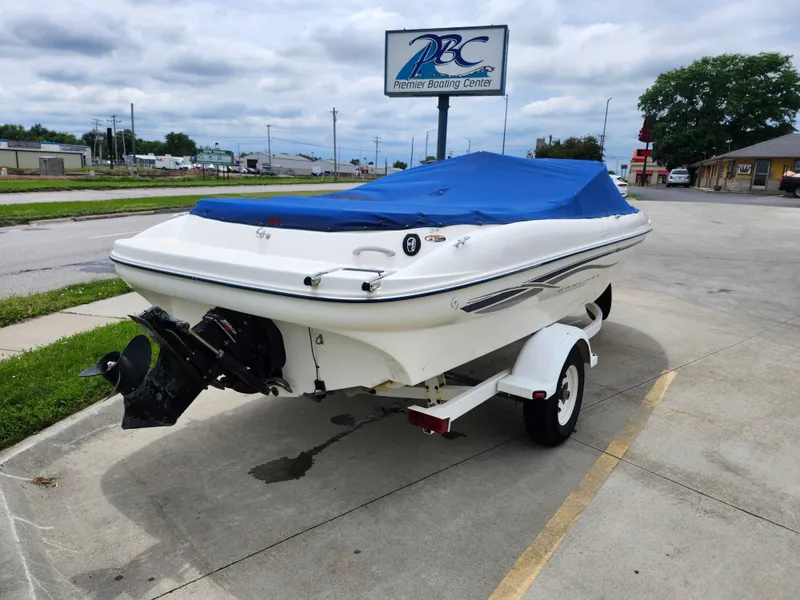 Slide: The Image of 2002 Bayliner 215 Capri boat with blue cover on trailer at Premier Boating Center. - 11