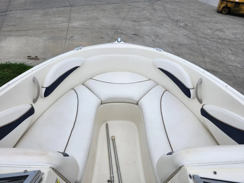 Slide: The Image of 2002 Bayliner 215 Capri boat bow seating area with white and navy cushions. - 22