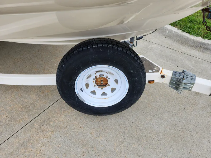 Slide: The Image of Close-up of a 2002 Bayliner 215 Capri boat trailer wheel on concrete. - 26