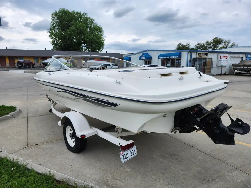 Slide: The Image of 2002 Bayliner 215 Capri boat on trailer in parking lot. - 4