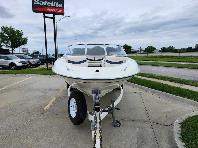 Slide: The Image of 2002 Bayliner 215 Capri boat on trailer in parking lot near Safelite AutoGlass. - 7