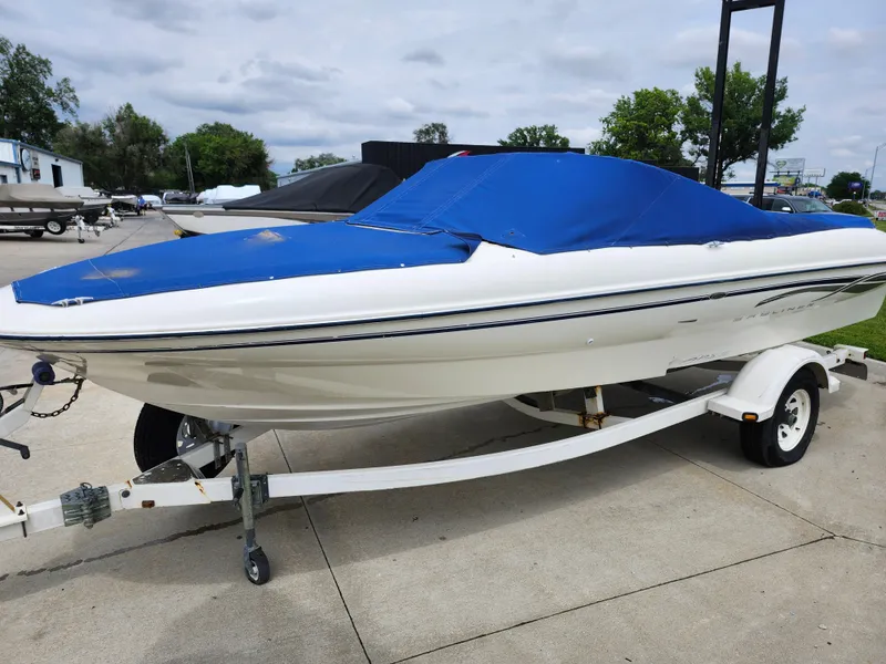 Slide: The Image of 2002 Bayliner 215 Capri boat with blue cover on trailer. - 8