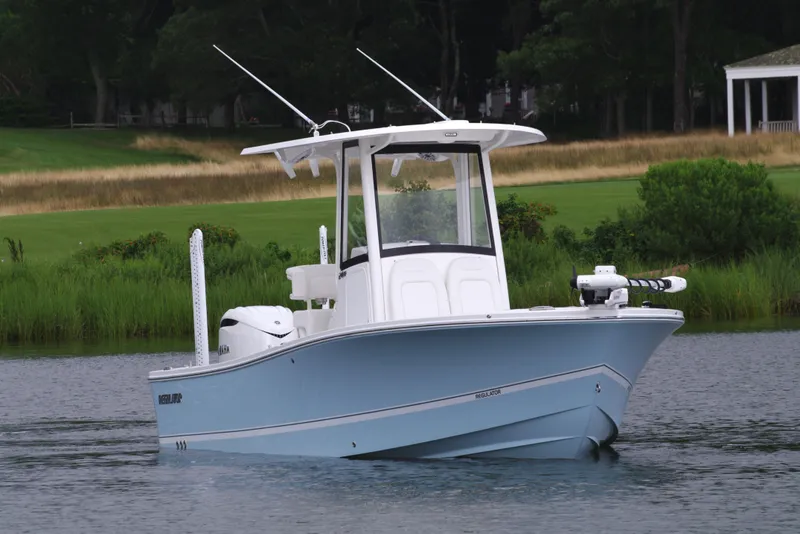 The Image of 2025 Regulator 24XO boat on calm water with lush greenery in the background. - 0