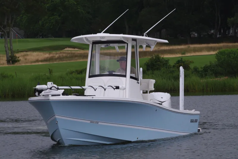 Slide: The Image of 2025 Regulator 24XO boat cruising on a calm lake. - 11