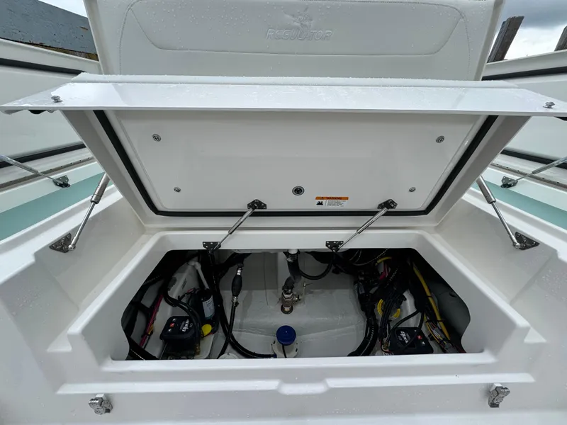 Slide: The Image of Open storage compartment of 2025 Regulator 24XO boat showing internal wiring and components. - 15
