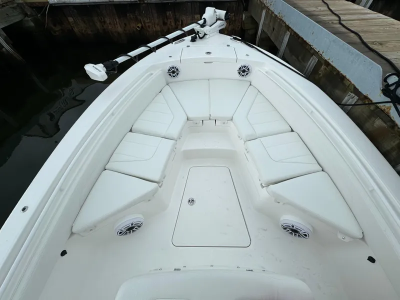 Slide: The Image of 2025 Regulator 24XO boat bow seating area with white cushions and speakers. - 28