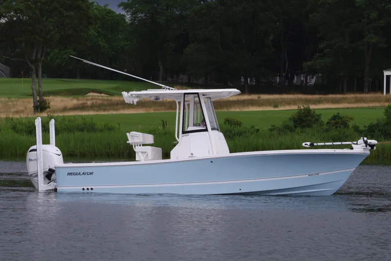 Slide: The Image of 2025 Regulator 24XO boat on calm water with lush green background. - 3