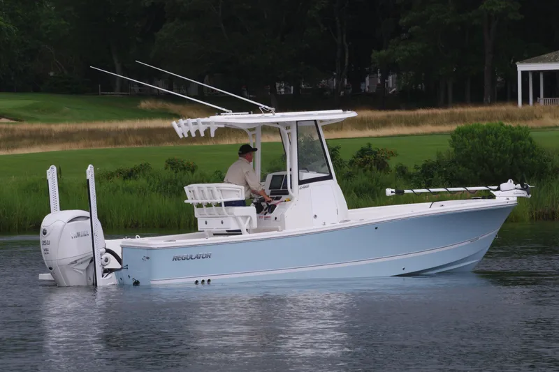 Slide: The Image of 2025 Regulator 24XO boat on calm water with a person at the helm. - 4