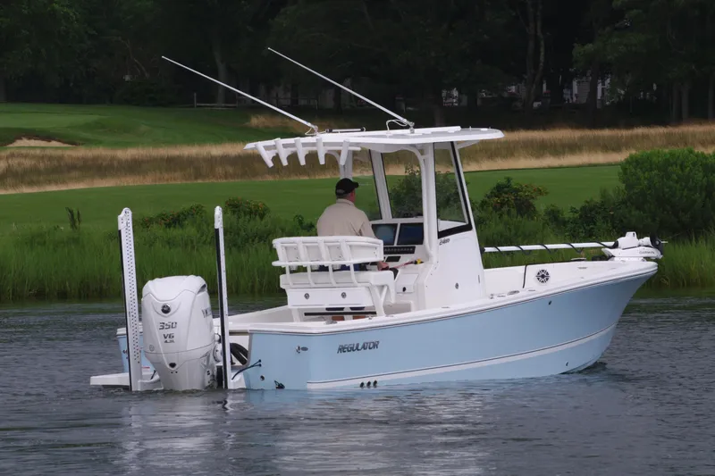 Slide: The Image of 2025 Regulator 24XO boat on calm water with lush green background. - 5