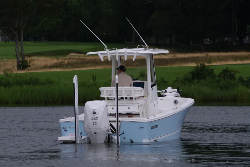 Slide: The Image of 2025 Regulator 24XO boat on calm water with lush green background. - 6
