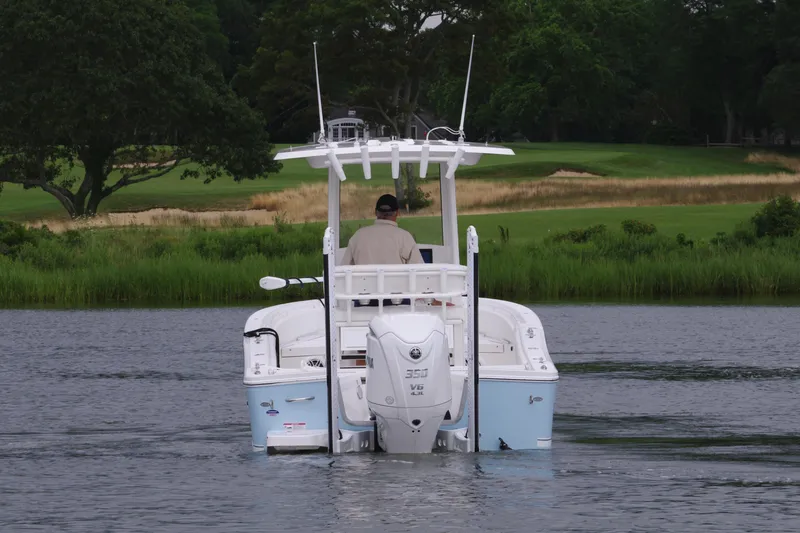 Slide: The Image of 2025 Regulator 24XO boat cruising on a calm lake with lush greenery in the background. - 7