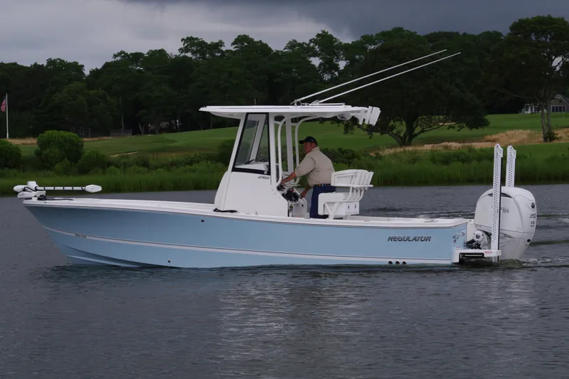 Slide: The Image of 2025 Regulator 24XO boat cruising on a lake with a person at the helm. - 9