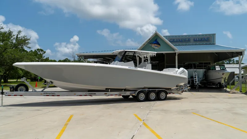 The Image of 2025 Fountain 38 TE boat on a trailer outside a marine dealership. - 1