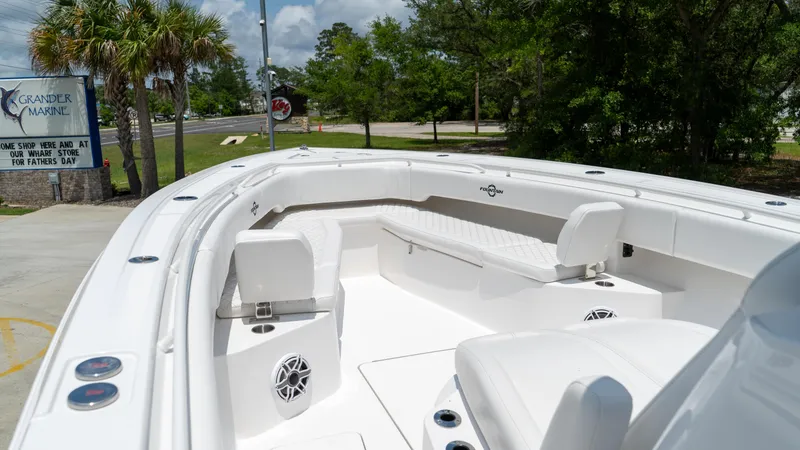 Slide: The Image of 2025 Fountain 38 TE boat with white seating and speakers, parked outdoors near palm trees. - 12