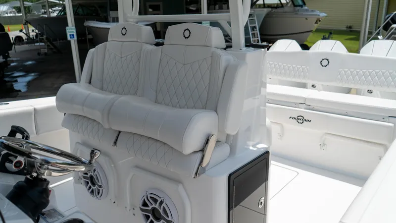 Slide: The Image of 2025 Fountain 38 TE boat interior with white cushioned seating and speakers. - 16
