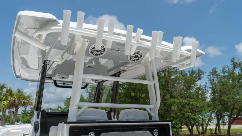Slide: The Image of 2025 Fountain 38 TE boat with rod holders and speakers under a clear sky. - 23