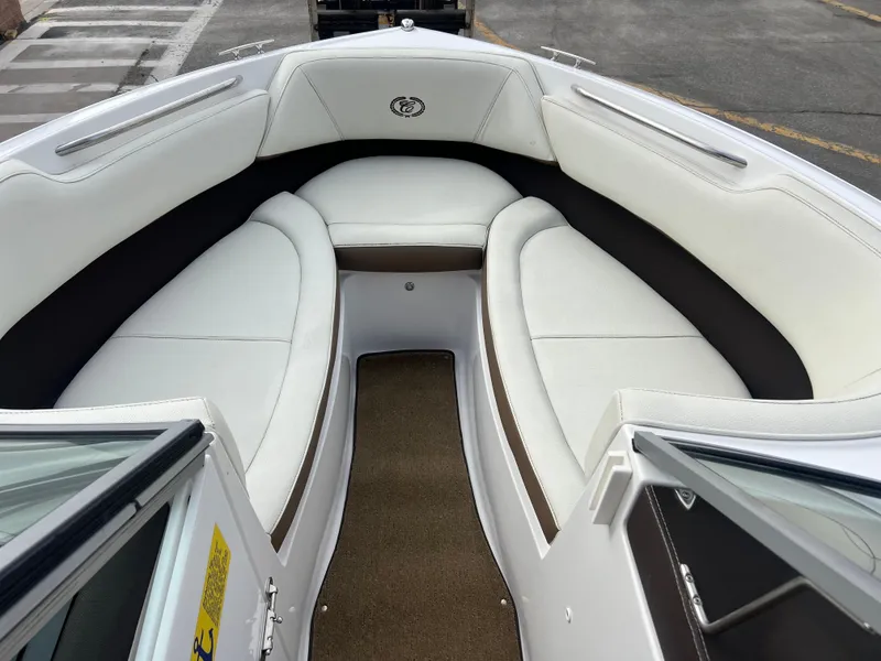 Slide: The Image of 2017 Cobalt 220S boat interior with white cushioned seating and brown accents. - 16